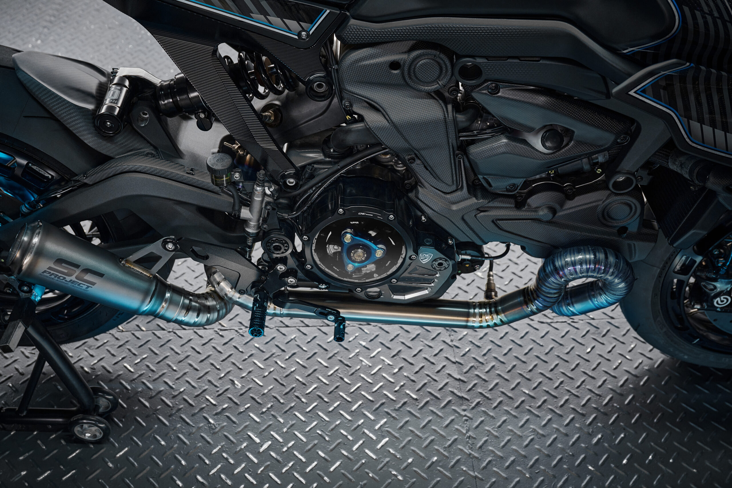 Detailed shot of the custom titanium exhaust system and carbon fiber trim Ducati Monster 937 Silhouette R by Rough Crafts